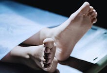 Image shows the lifeless body of a young boy on a hospital bed, related to a murder case