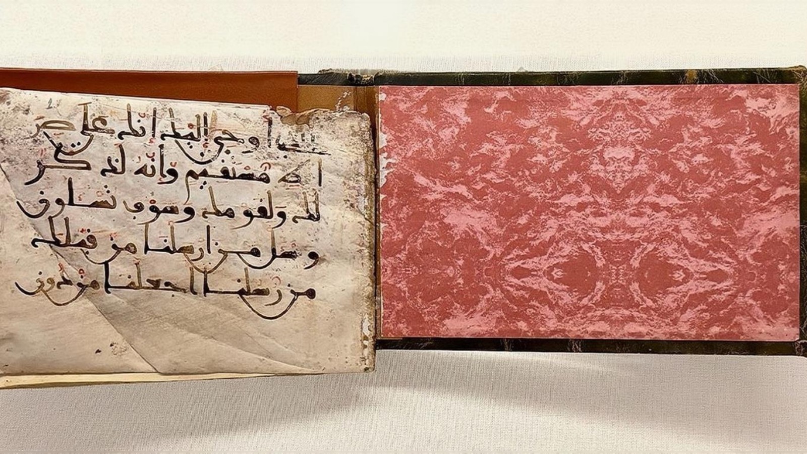 Rare handwritten Quran manuscript with aged pages and Arabic calligraphy, displayed in Makkah.