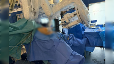 Robotic surgical system performing a minimally invasive liver procedure in an operating theatre.