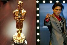 Shah Rukh Khan reacts as he receives an Oscar honour, standing confidently on stage.