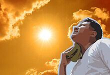 Person relaxing outdoors during sunset with a vibrant sky and clouds in the background.