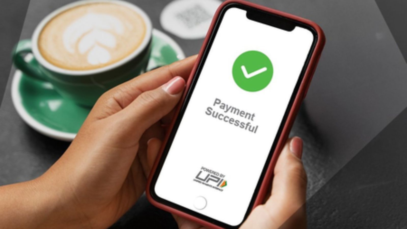 Image shows A hand holds a smartphone displaying a