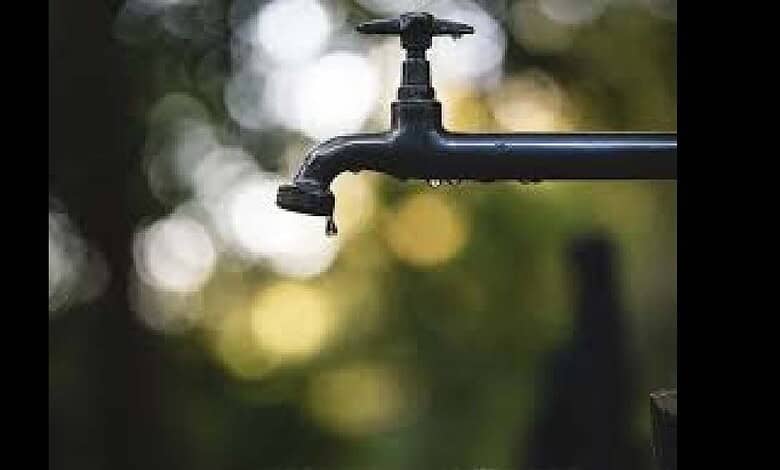 Outdoor water tap with a blurred natural background, eco-friendly water conservation concept.