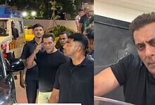 A man taking a selfie with a serious expression, surrounded by a group of people in an outdoor setting at.