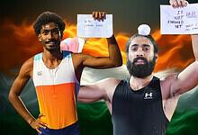 Two male athletes holding signs, celebrating victory with Indian flag in the background.