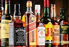 A variety of liquor bottles displayed on a shelf, representing Karnataka's record-breaking alcohol sales.