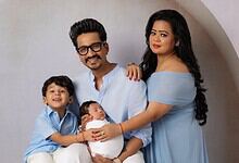 A happy family portrait of parents with two children, celebrating a joyful moment indoors.