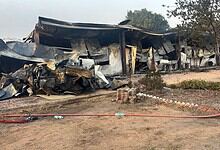 Burned and damaged structures after fire incident at a building site. Charred remains and debris visible.