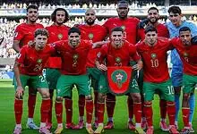 Moroccan football team in red jerseys on the field during a match at the FIFA World Cup.