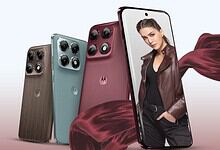 A woman holding a smartphone with multiple camera lenses, showcasing new mobile phone models.