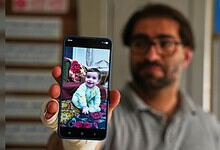 Child taking a selfie with a smartphone in a library setting.