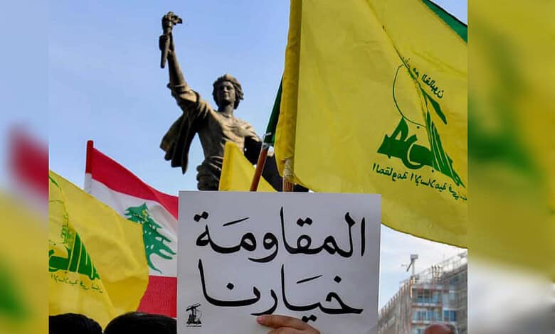 Hezbollah supporters hold the group's flags, the Lebanese flag and a placard reading "Resistance is our choice" during a protest in Beirut.