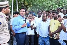 Community meeting with police officer and residents in Hyderabad, discussing housing issues.