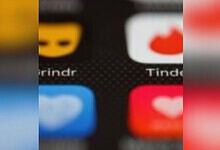 Close-up of dating app icons on a smartphone screen, including Tinder and Grindr.