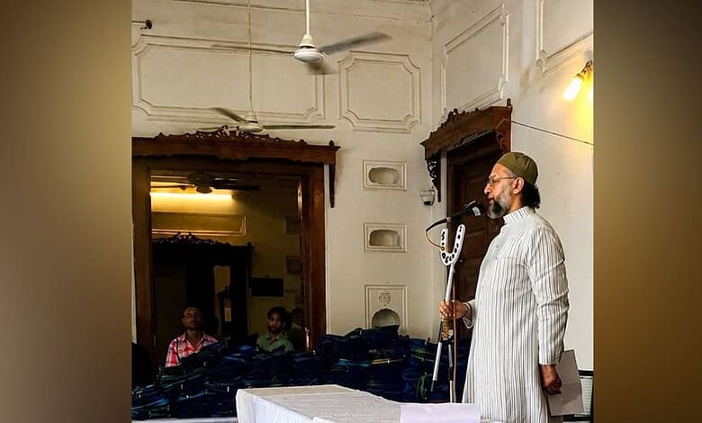 Asaduddin Owaisi speaking at a public event with a microphone in hand.