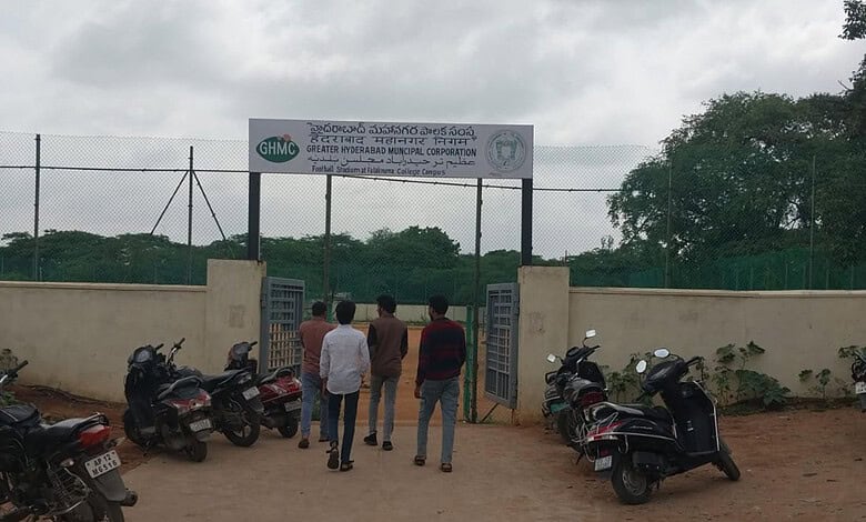 Group of young men standing outside a gated sports facility in Hyderabad, India.