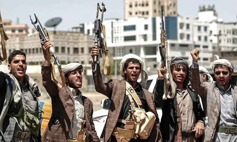Houthi fighters holding rifles during a protest in Yemen.