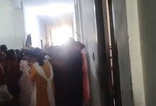 Students involved in a clash over stolen phones at Andhra college, with a crowd gathered in a corridor.