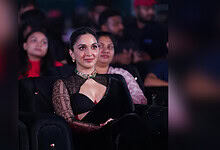 Kiara Advani attending an event in a black saree with lace sleeves and a choker necklace.