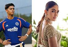 Cricketer in blue jersey with hands on hips, woman in gold dress with earrings, outdoor setting.