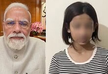 Indian Prime Minister Narendra Modi with a woman in a striped shirt, both indoors.