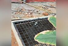 Drain cover with a black grate installed on a construction site.