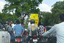 A Hyderabad Traffic police constable stands near a signage on the KBR Park road near Jubilee Hills on the first day of the first day of the road turning one way.