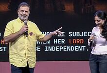 Rahul Gandhi and a woman speaking on stage during a public event.