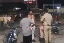Police officer and civilians involved in a confrontation on a street at night.