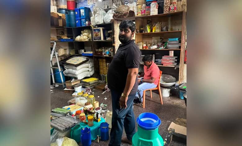 Man inspecting sweets at a local shop during police raid in Uppal.
