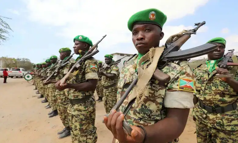 Ugandan soldiers in uniform holding rifles during a training or parade event.