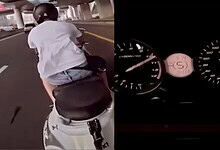Biker riding a scooter at high speed on a city road, performing stunts.