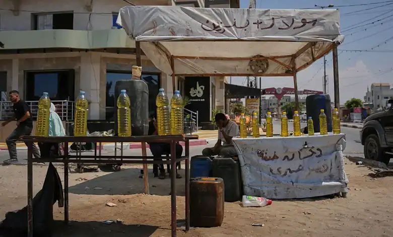 Street vendor selling bottles of cooking oil under a makeshift tent in Gaza.