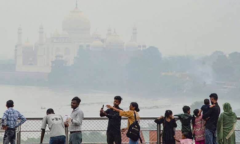 Agra Tourists view the Taj Mahal across the Yamuna river as cloudy weather keeps the sky hazy, in Agra, Uttar Pradesh, Friday, Aug. 14, 2026.
