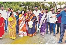 Group of people protesting and pouring water on roads during a Dalit protest in India.