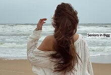 Woman with long hair on the beach, facing the sea, in a white sweater, seniors in Bigg Boss 20.