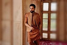 Bilal Abbas Khan wearing traditional attire, standing indoors with a wooden window in the background.