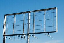 Empty billboard frame against a clear blue sky in Hyderabad.
