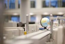 Modern laboratory with computers and a globe, focusing on science and technology.