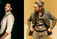 Two men in stylish outfits, one with a beard and the other with glasses and a bun hairstyle.