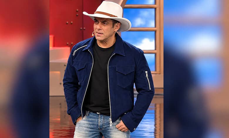Salman Khan in a blue jacket and white hat on the Bigg Boss set.