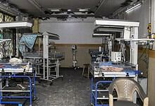 Empty hospital operating room with surgical tables and equipment.