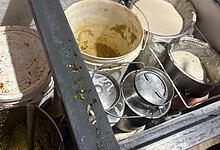Dirty kitchen utensils and containers in a restaurant kitchen.