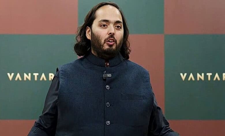 Anant Ambani speaking at an event with a VANTAA backdrop behind him.