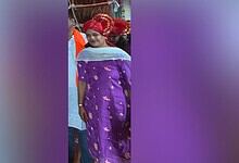 Woman in traditional purple attire and red headscarf at a cultural event in Hyderabad.