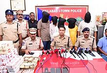Police officers and suspects with seized cigarettes at Adilabad I-Town Police station.