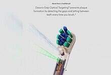 Dyson electric toothbrush with green and blue bristles and laser light for teeth cleaning.