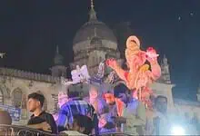 Ganesha idol during Ganesh procession at Charminar in Hyderabad, illuminated at night.