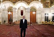 Pezeshkian standing in the grand hall of Rashtrapati Bhavan with ornate ceiling and chandeliers.