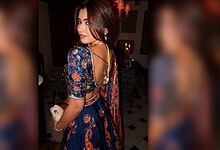 Young woman in traditional Indian attire at an indoor event, looking over her shoulder.